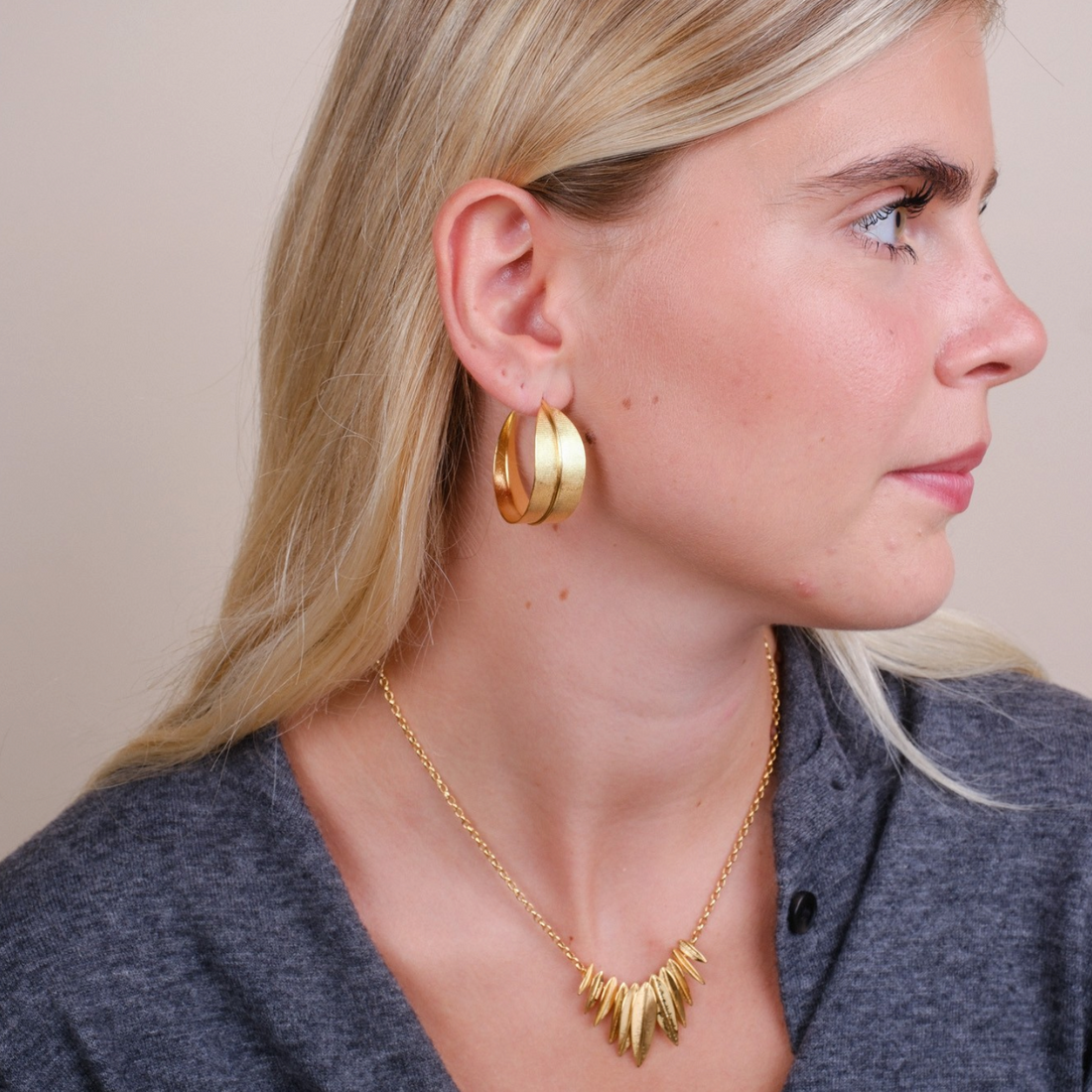 EC One Phoenix large hoop earrings in gold plated finish worn by a woman with blonde hair