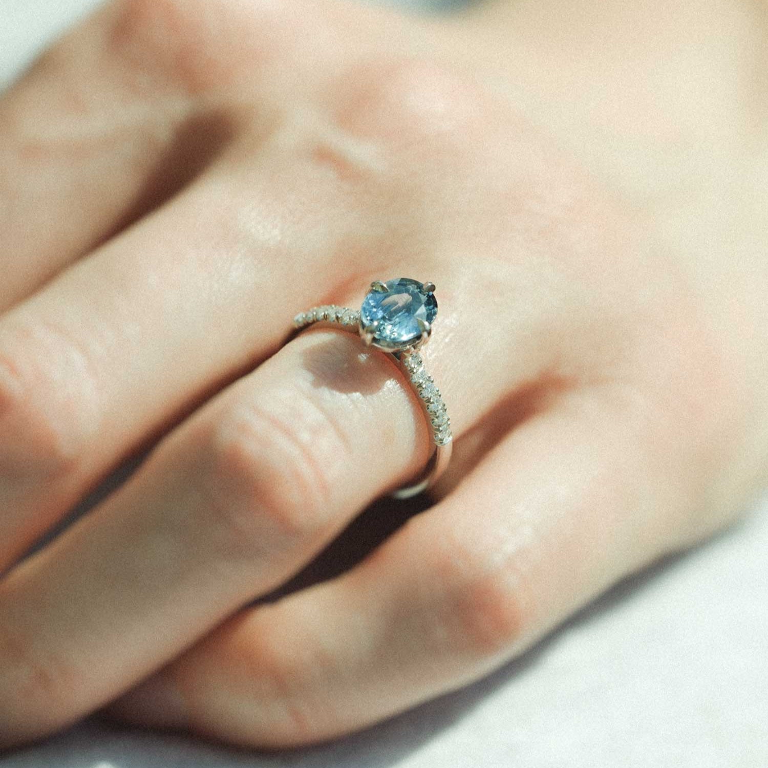 MILA Platinum Solitaire Ring with Oval Teal Sapphire and Diamond Shoulders made in recycled platinum by ethical jeweller E.C.One London in our B Corp certified workshop