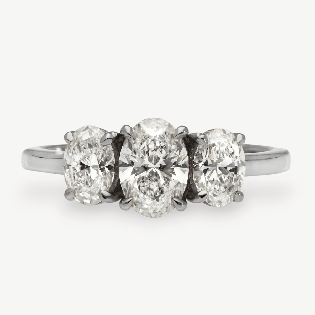 EC One Olivia trilogy engagement ring featuring three oval diamonds set in recycled platinum on a white background.