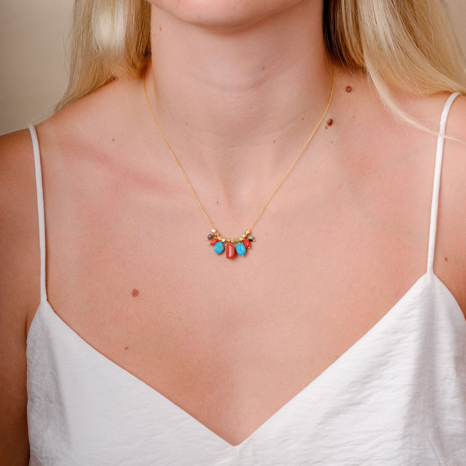 EC One Collette necklace featuring coral and turquoise beads on a gold plated recycled silver chain worn on a model