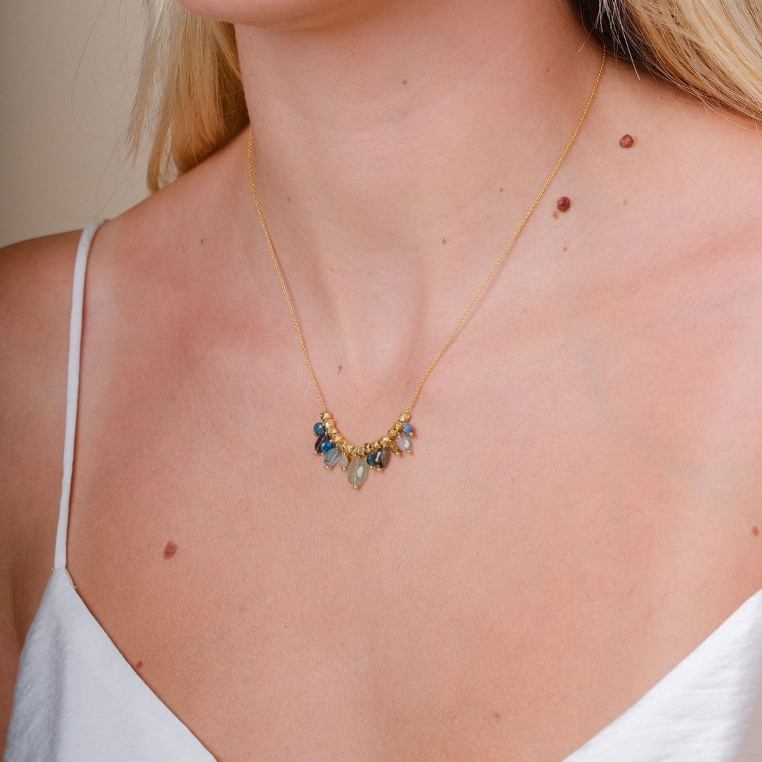EC One Collette necklace featuring blue sapphire, apatite, and green garnet beads on a gold plated recycled silver chain