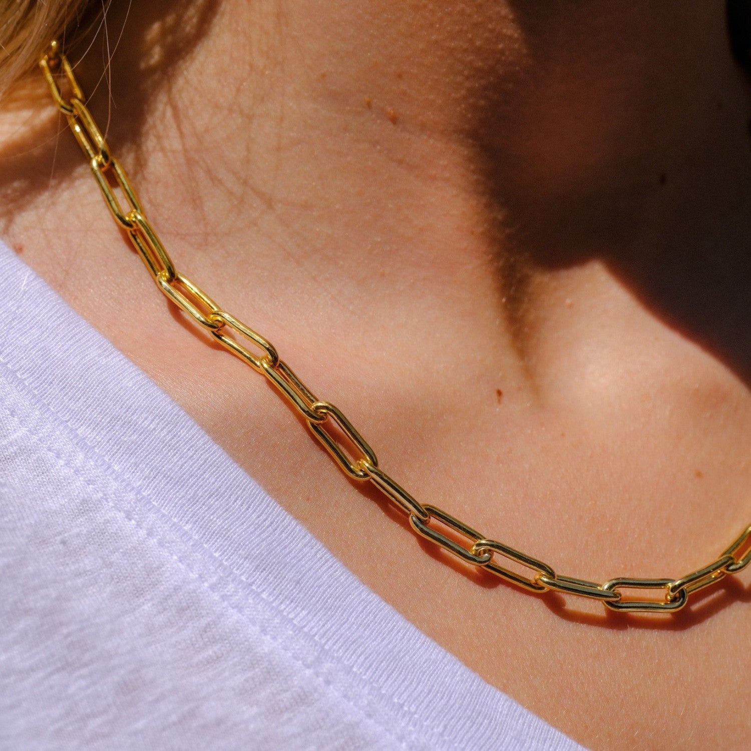 EC One gold plated recycled silver heavy paperclip chain necklace worn on a model in a white t-shirt