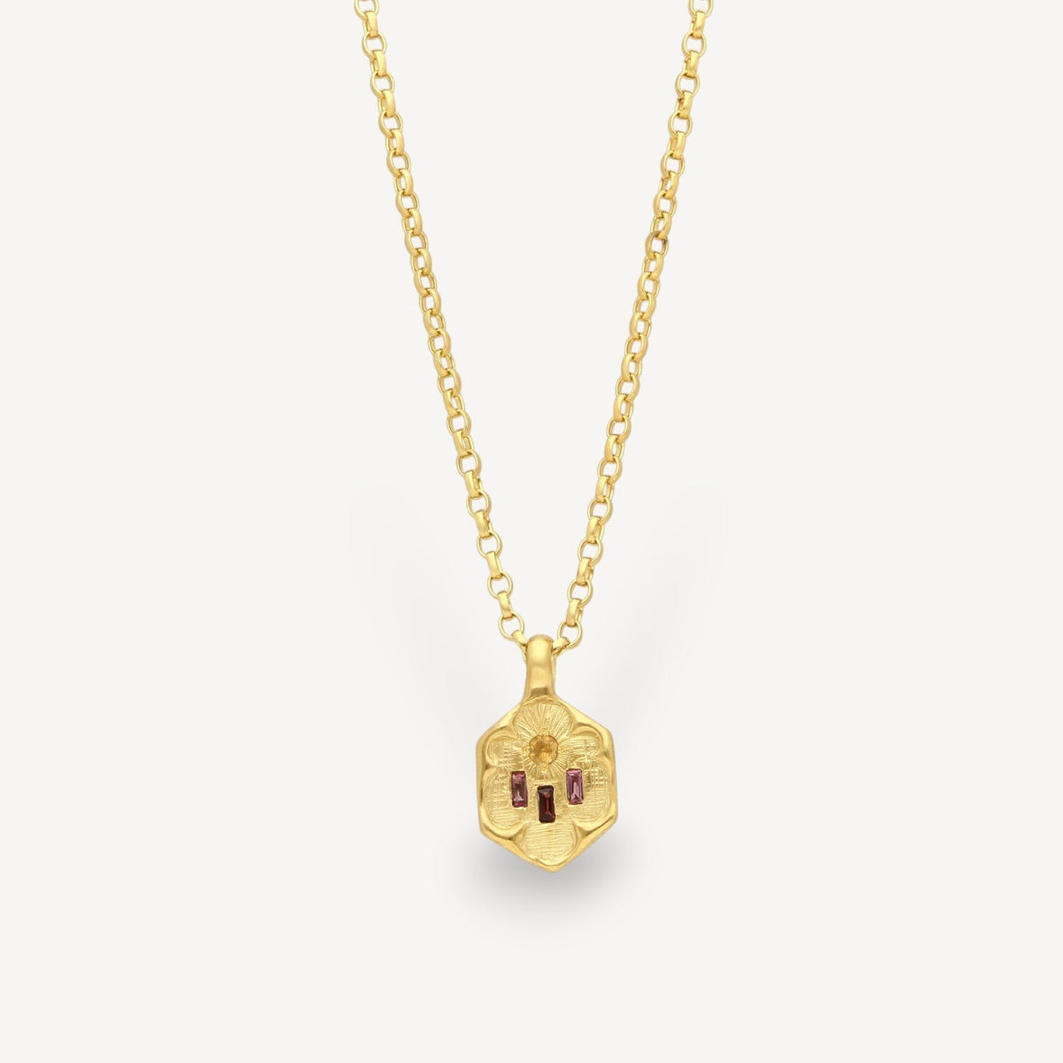 EC One gold plated pendant necklace featuring a hexagonal charm with floral engraving and three pink baguette gemstones