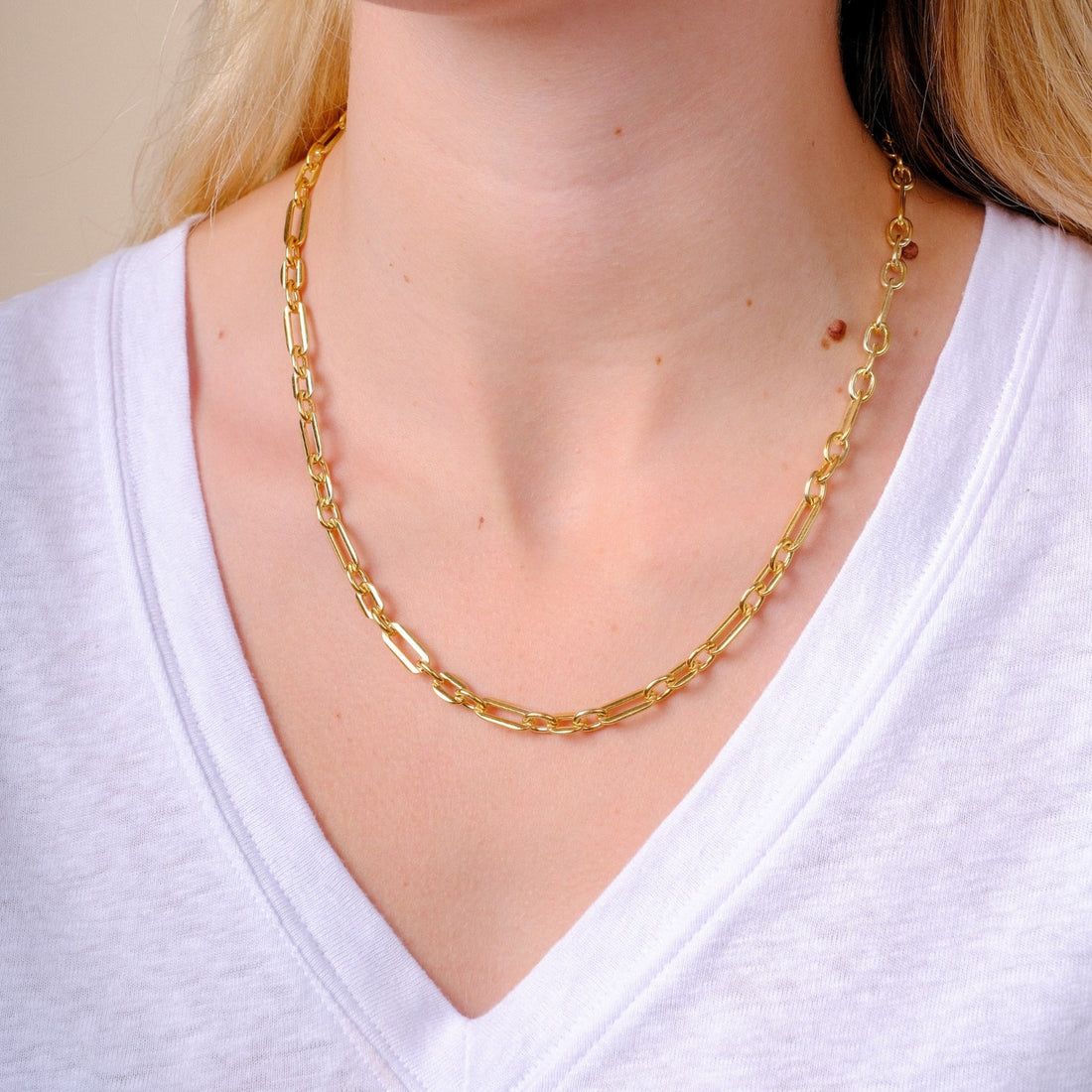 EC One heavy gold plated recycled silver figaro chain necklace worn on a model in a white v-neck shirt