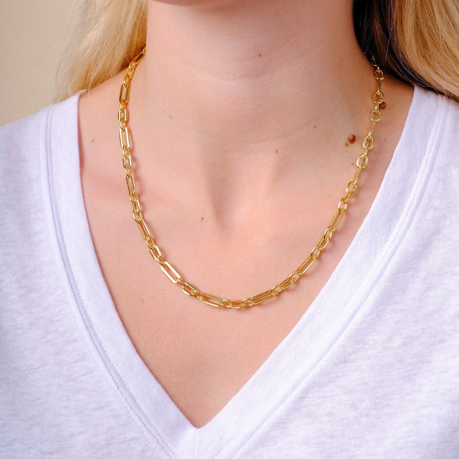 EC One heavy gold plated recycled silver figaro chain necklace worn on a model in a white v-neck shirt