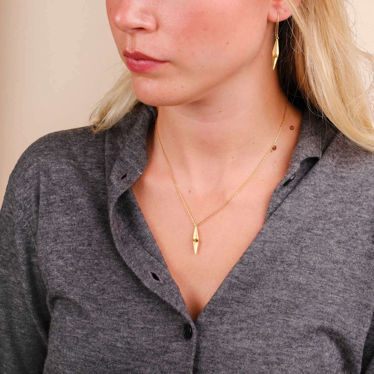 EC One gold plated silver shard drop necklace worn by a woman with matching shard earrings