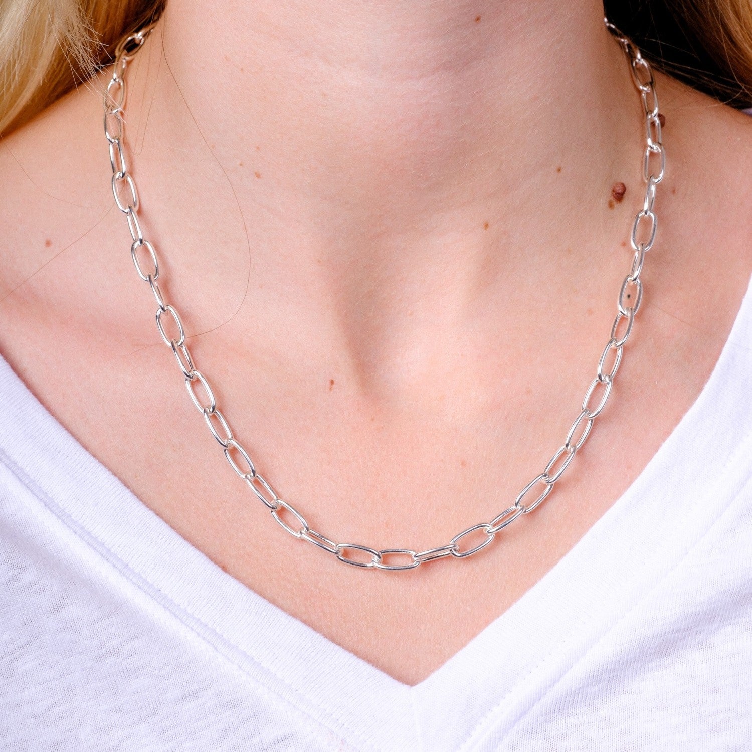 EC One heavy recycled silver oval link necklace worn on a model with a white v-neck top