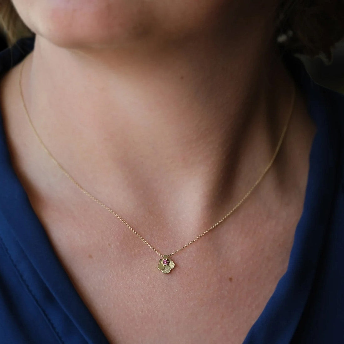 EC One Jo Hayes Ward 18ct yellow gold hex fan pendant necklace with a small ruby worn on a model