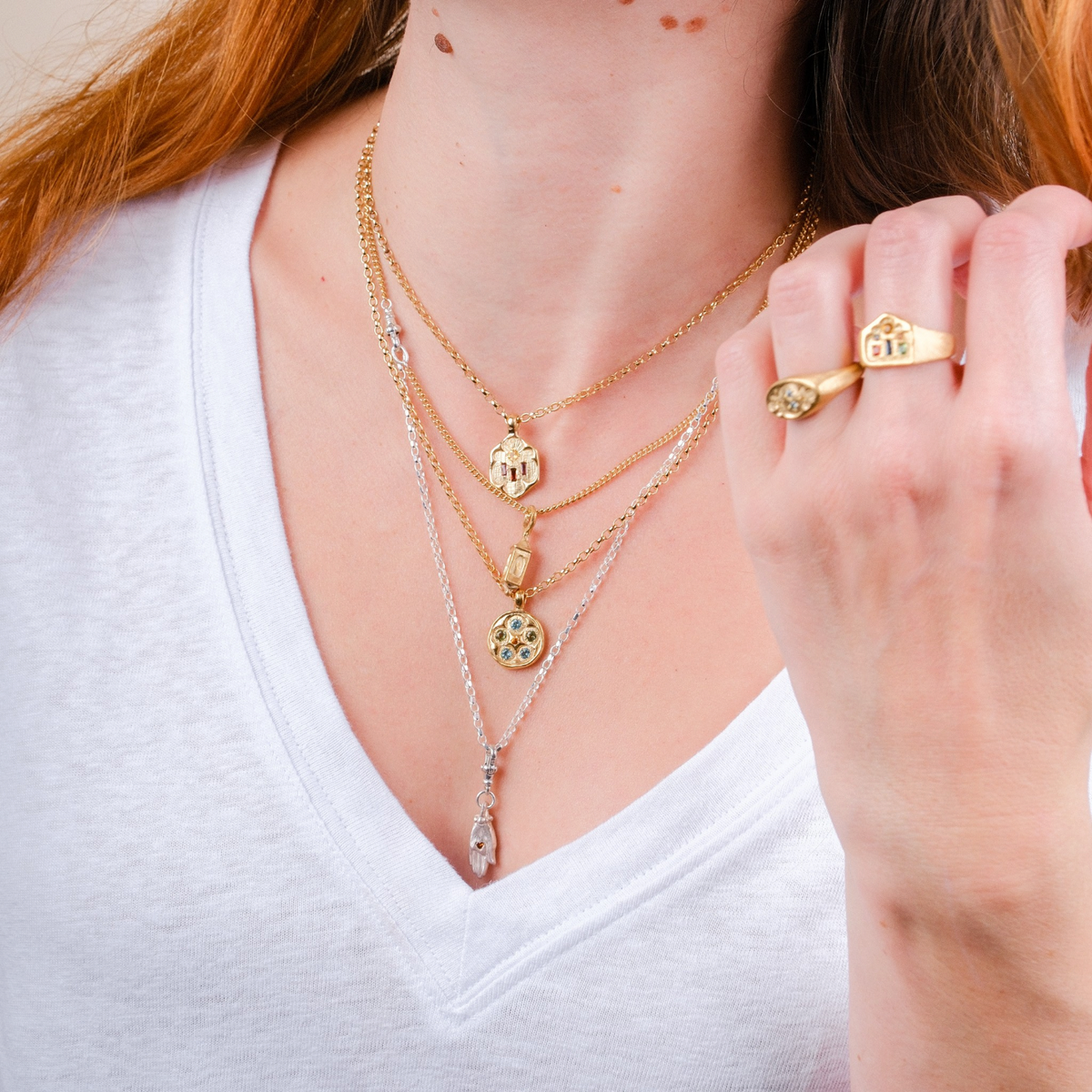 EC One layered gold and silver pendant necklaces with autumnal gemstones worn on a model in a white v-neck top