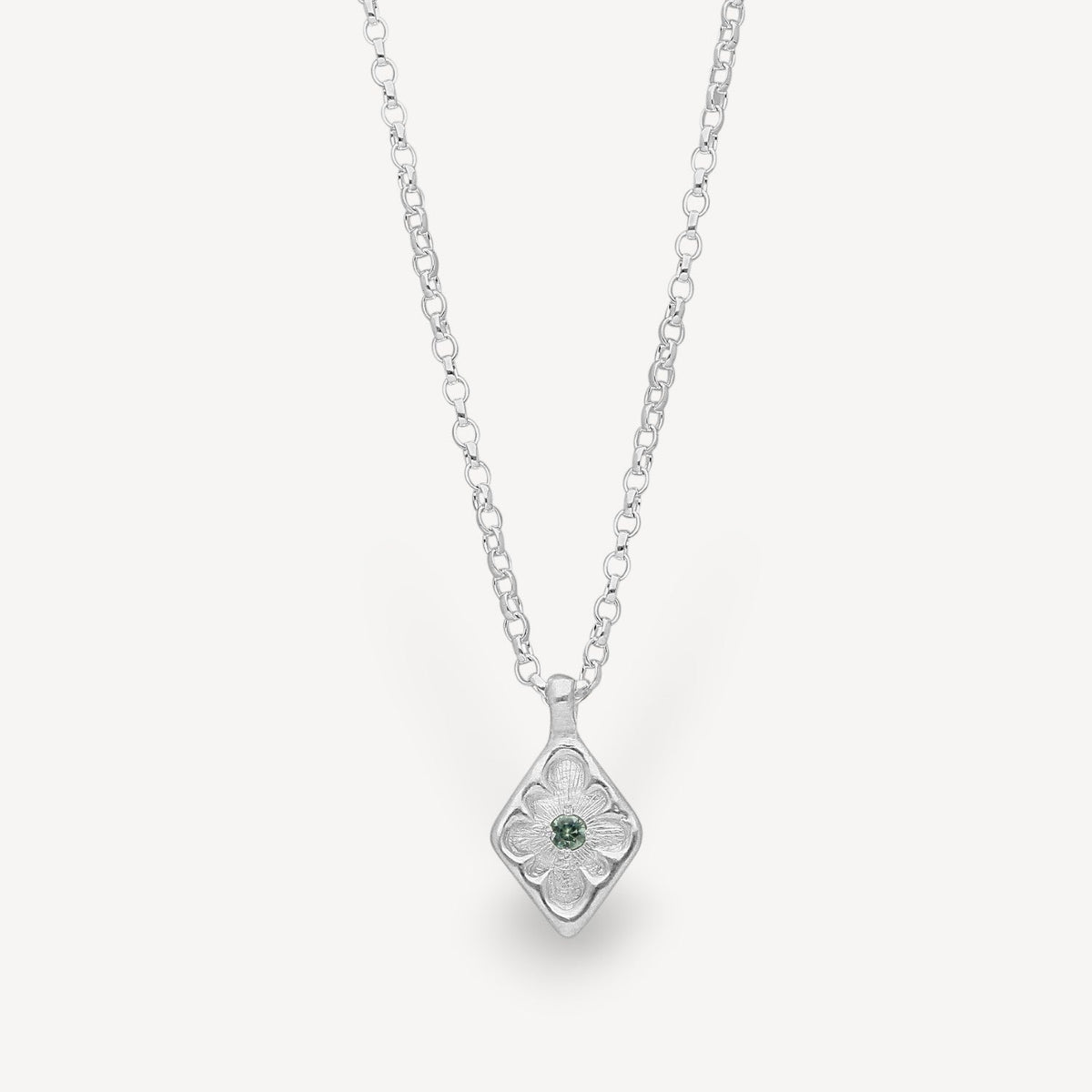 EC One lozenge-shaped silver pendant necklace featuring an intricate floral engraving and a central green sapphire.