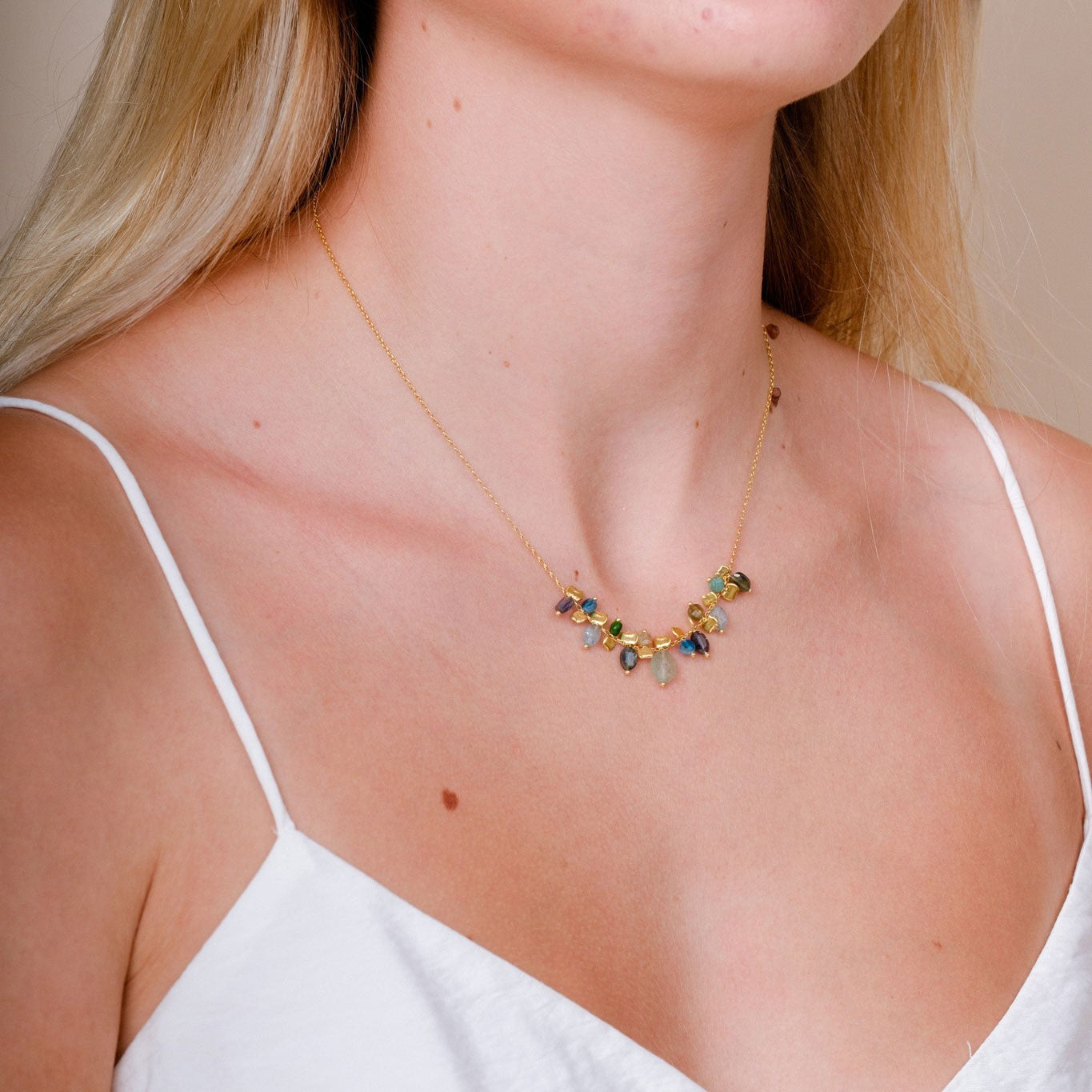 EC One PETALO necklace featuring blue sapphire, apatite, and green garnet gemstones on gold plated recycled silver.
