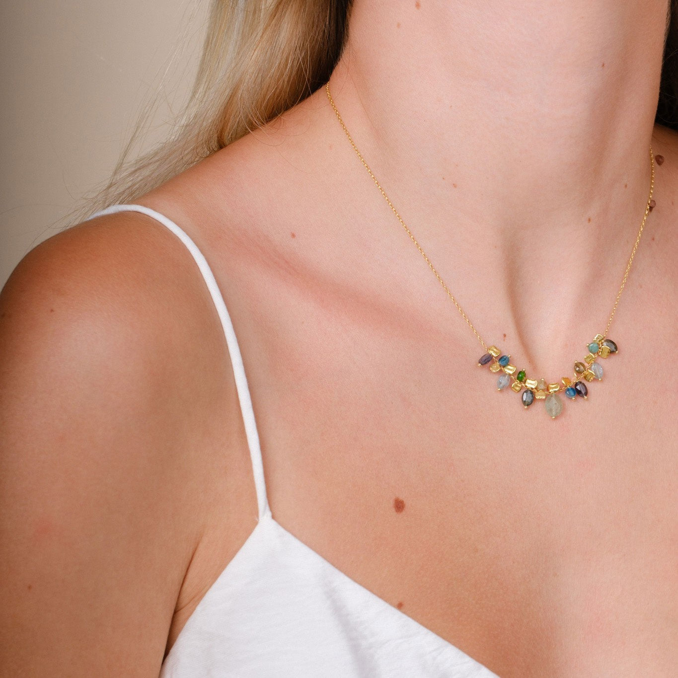 EC One PETALO necklace featuring blue sapphire, apatite, and green garnet gemstones on gold plated recycled silver.