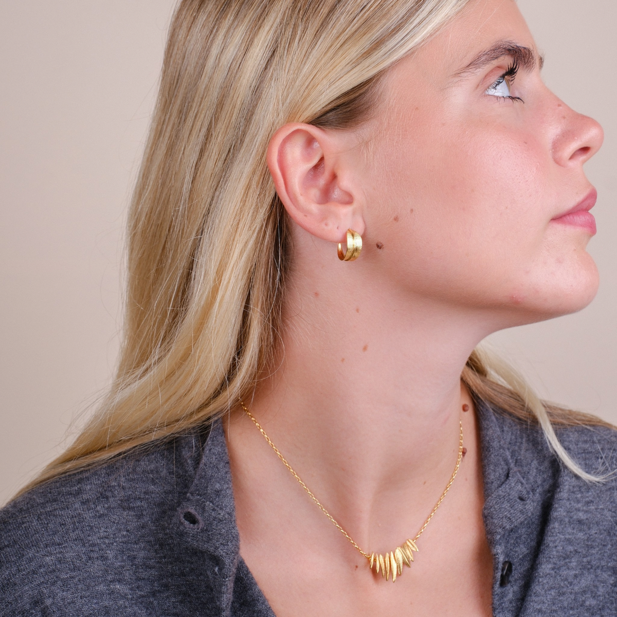 EC One Phoenix small gold plated hoop earrings worn by a blonde woman in profile view
