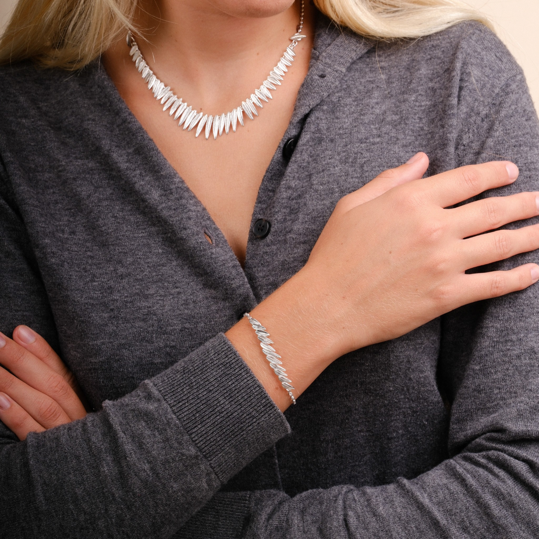 EC One Phoenix Plume silver bracelet worn on a woman's wrist, featuring a delicate feather-inspired design.