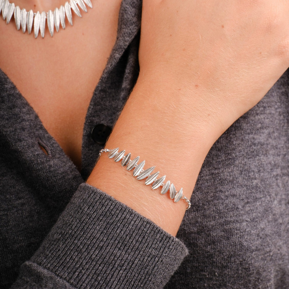 EC One Phoenix Plume silver bracelet featuring a delicate feather-like link design worn on a model's wrist