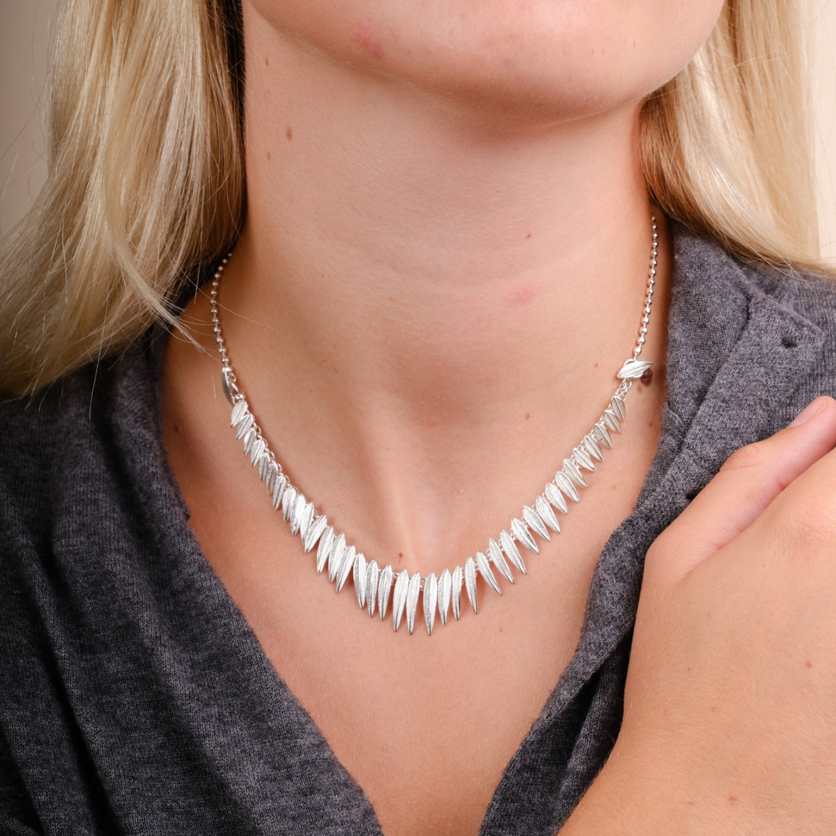 EC One Phoenix silver necklace and bracelet set featuring textured leaf-shaped links worn by a blonde model.