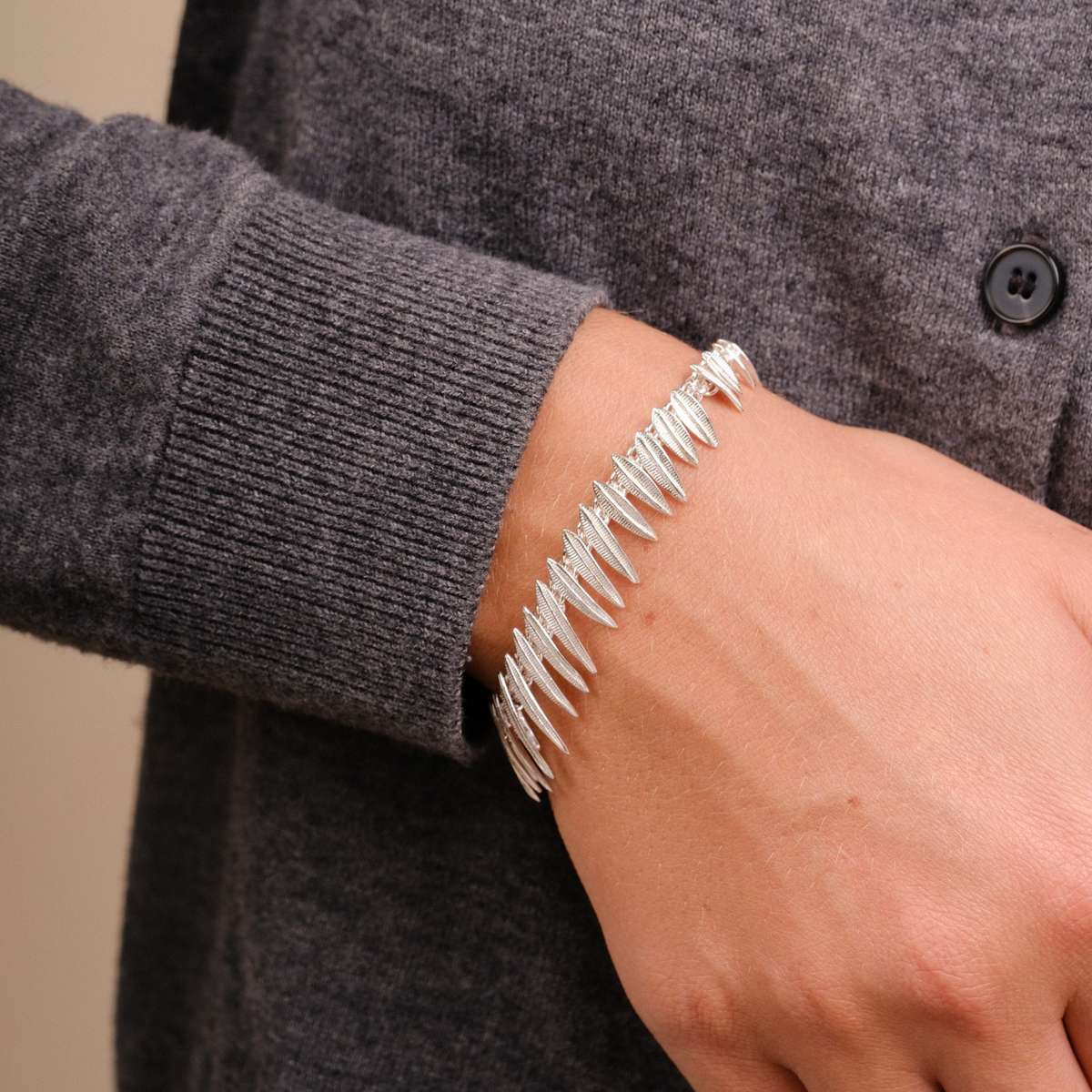 EC One Phoenix silver bracelet featuring a unique spike-like link design worn on a wrist with a grey sweater.