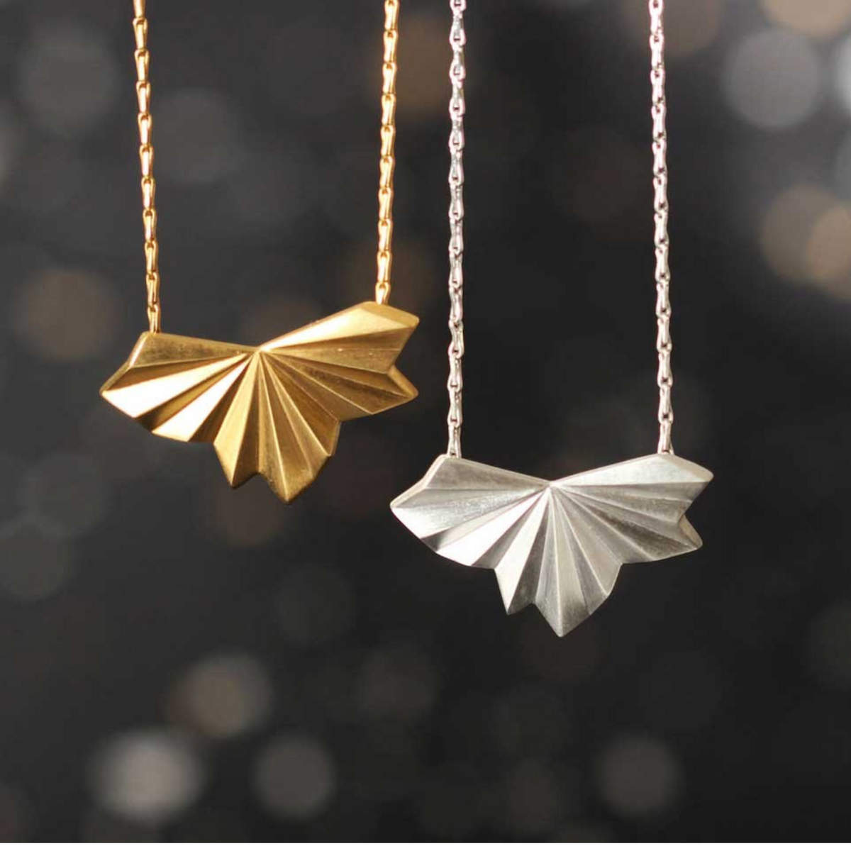 EC One pleated fan pendants in silver and gold on adjustable hayseed chains with a contemporary art deco design.