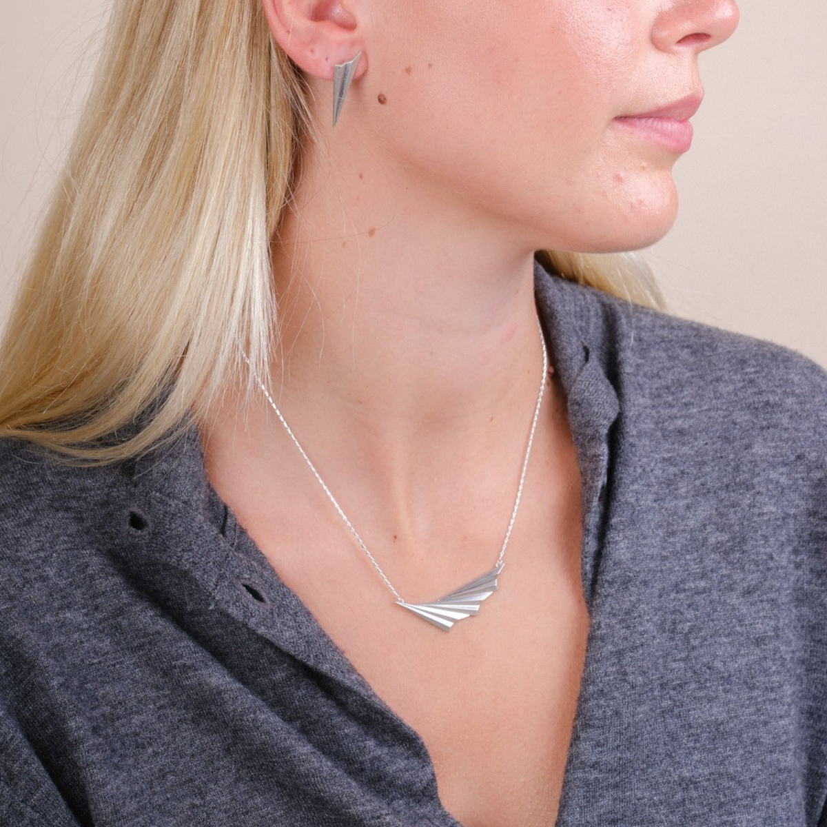 EC One Pleated Wave necklace in recycled silver featuring an asymmetric fan pendant worn by a blonde model