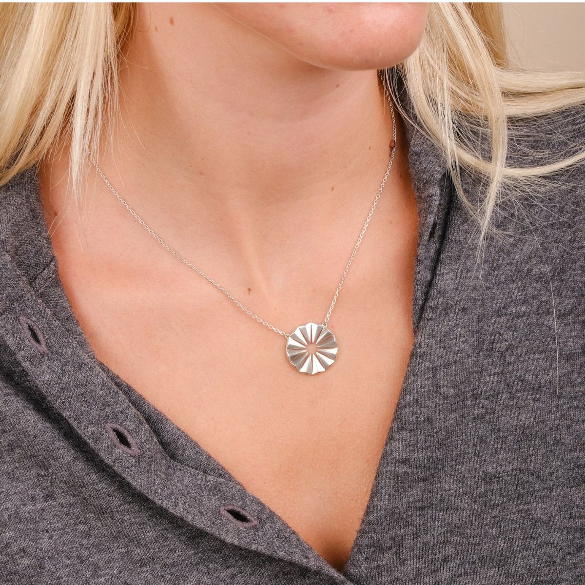 EC One Polaris Radial necklace in recycled sterling silver worn on a model with a grey button-down top