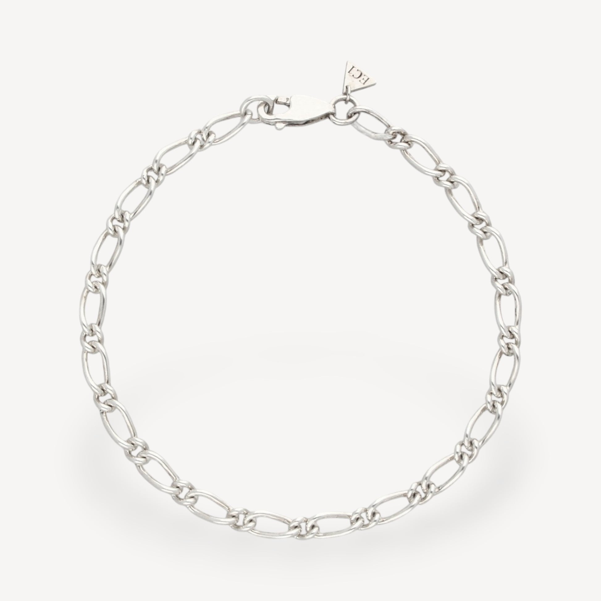 EC One 4mm wide recycled silver figaro chain bracelet with a lobster clasp closure on a plain background.