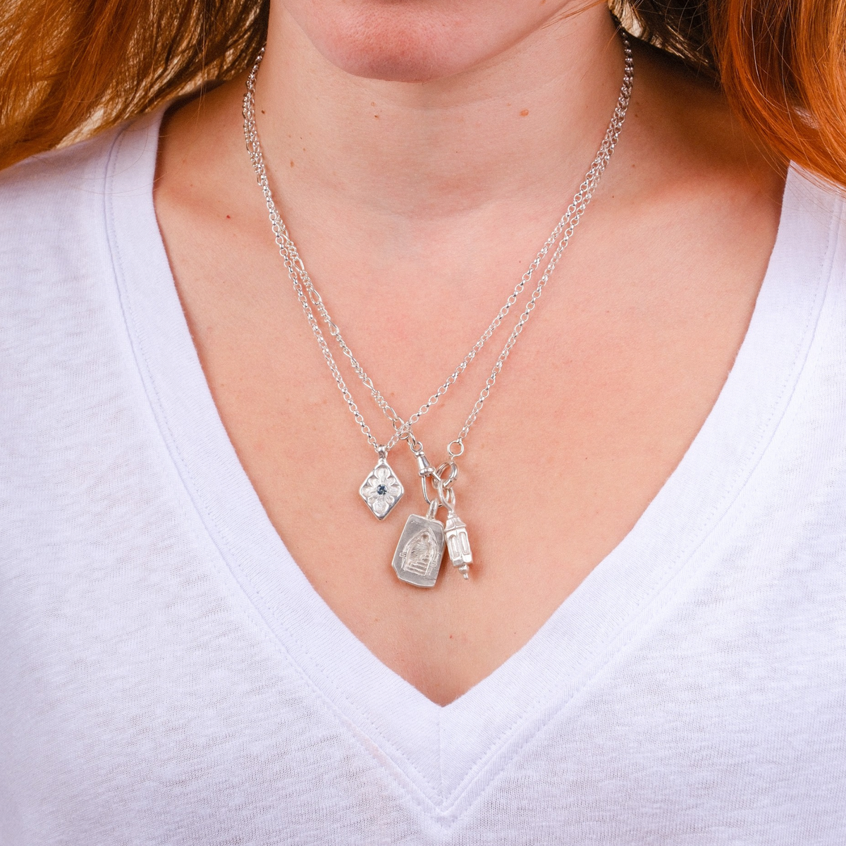 EC One silver Doorway Charm necklace featuring hand-carved wax pendants on a delicate chain worn by a woman