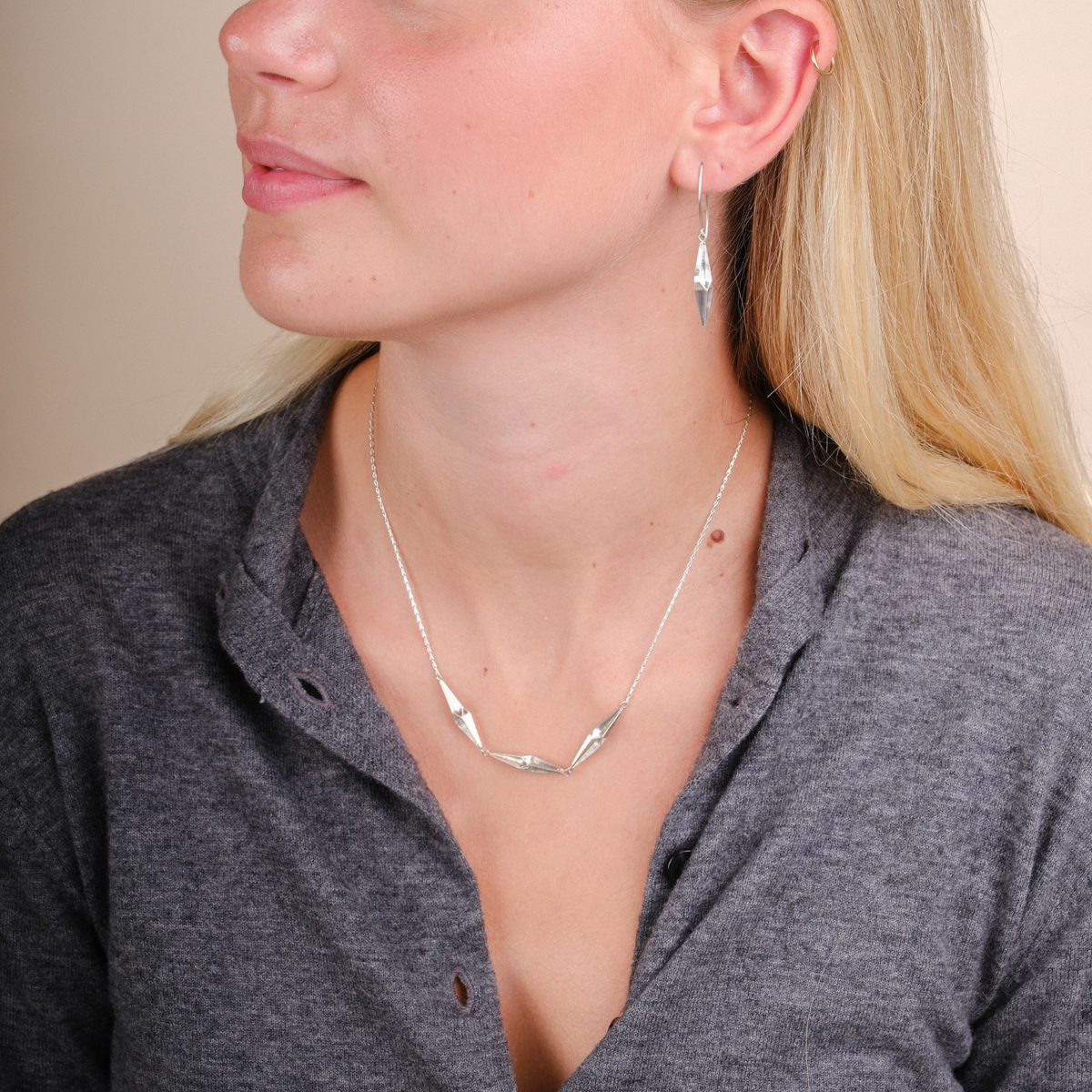 EC One silver triple shard necklace worn by a woman with matching shard earrings
