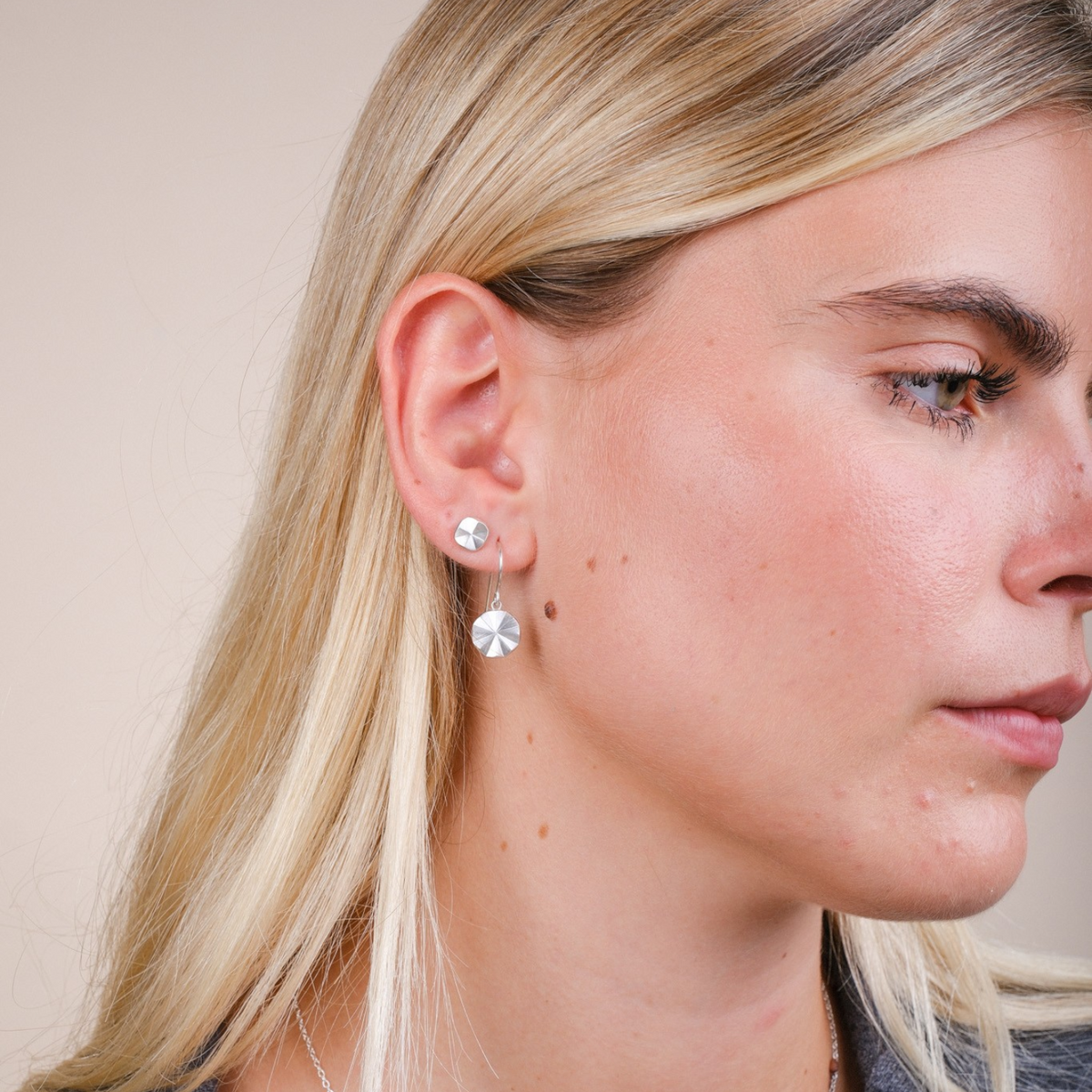 EC One Polaris starburst drop hook earrings in recycled silver worn by a model with a matching starburst necklace