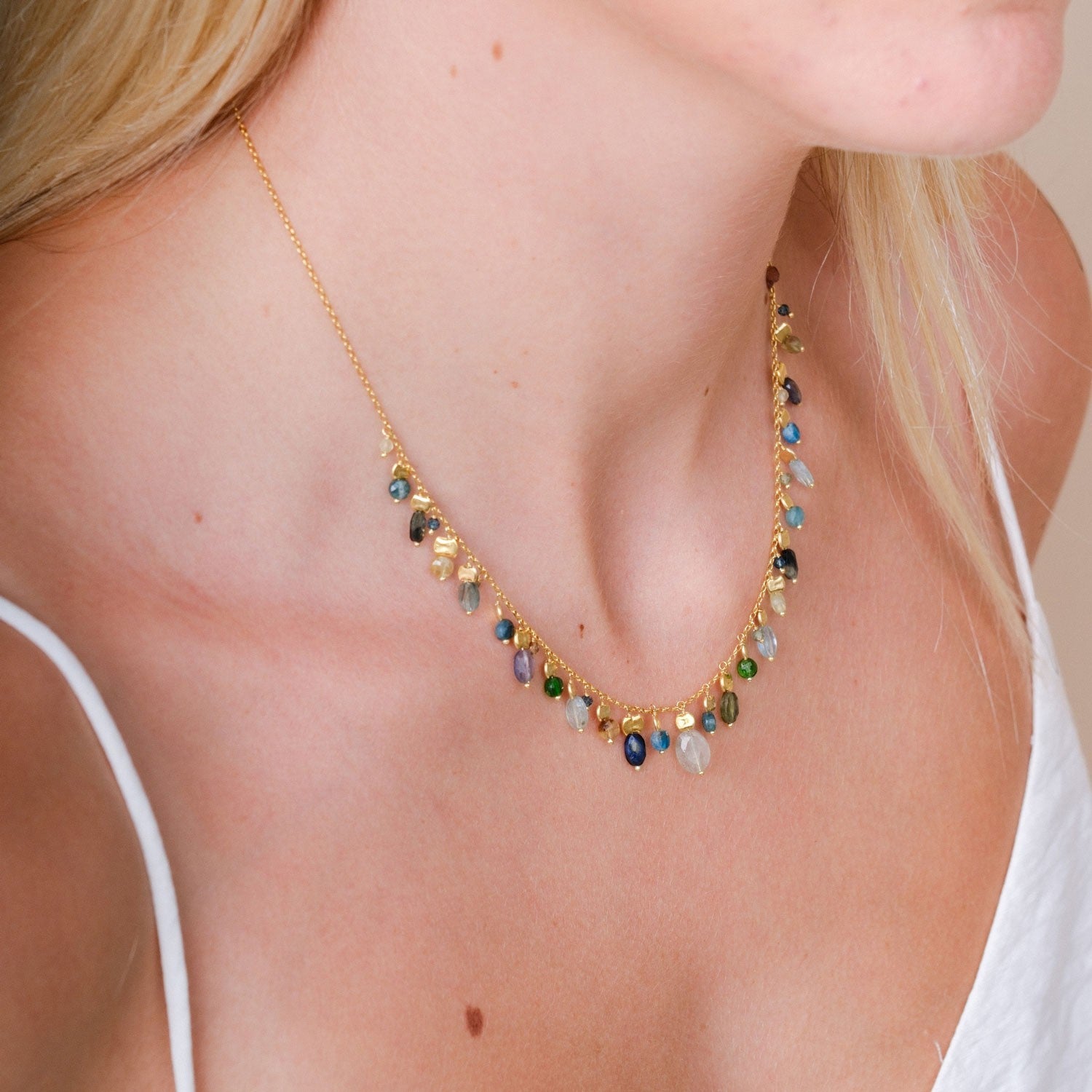 EC One Stellina necklace featuring gold plated silver chain with blue apatite, green garnet, and iolite gemstones.