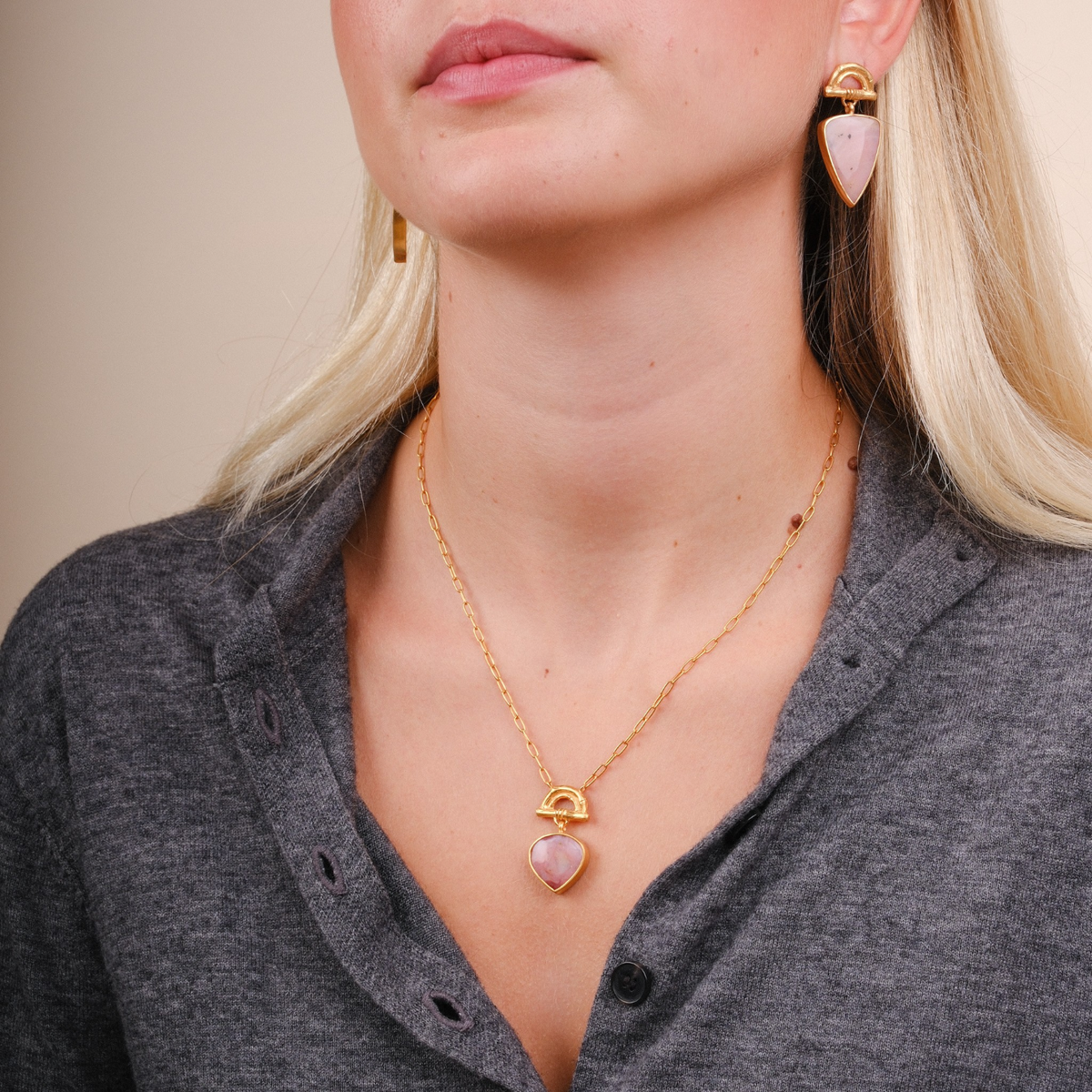 EC One SUNRISE pendant featuring a pear-shaped pink opal on a gold-plated chain worn by a model with matching earrings