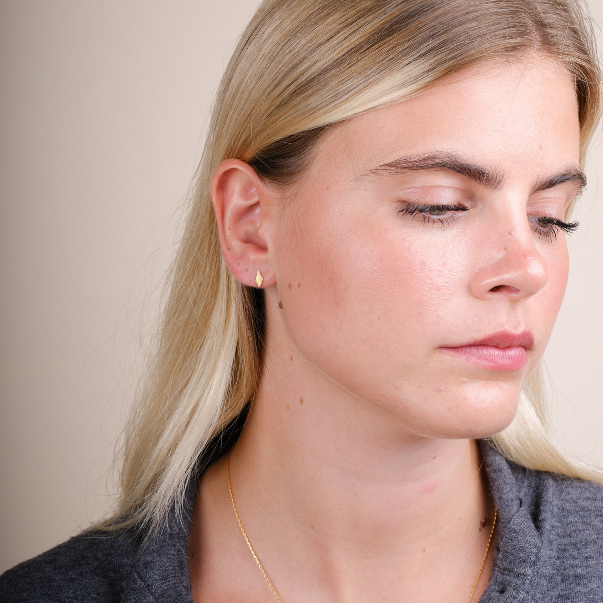 EC One Tiny Pleated gold plated recycled silver stud earrings worn by a model, featuring an angular peaked design.