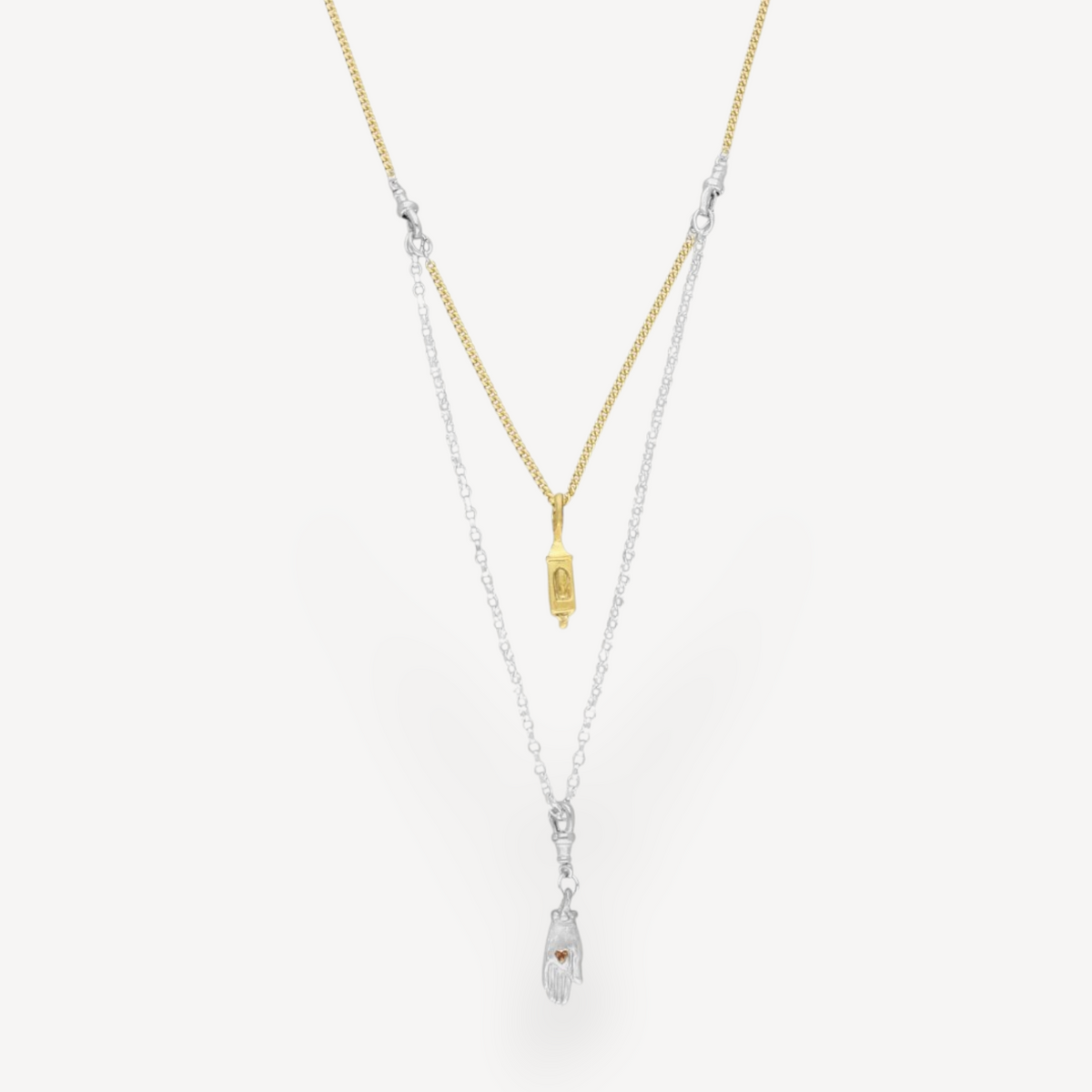 EC One interchangeable two-tone necklace featuring a gold lantern charm and a silver hand charm on a mixed metal chain.